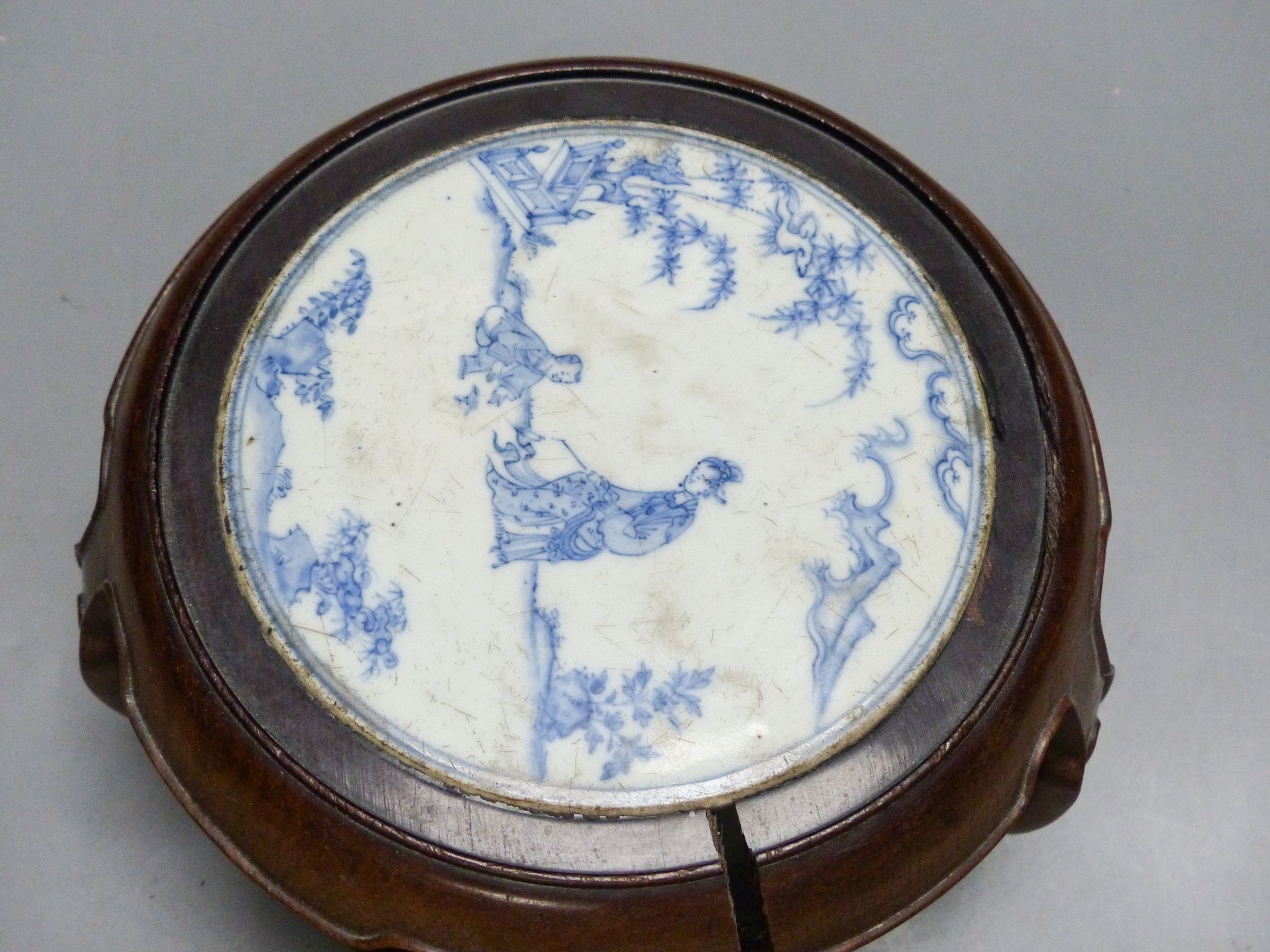 A 19th century Chinese blue and white circular tile inset hongmu stand, 22cm